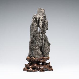 A Chinese ying stone scholar's rock on wooden stand, 20th C.