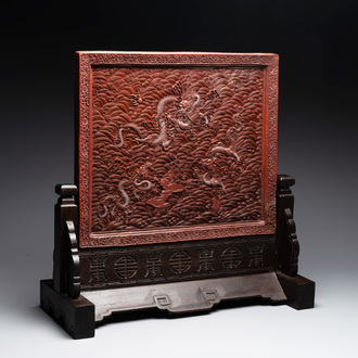 A rectangular Chinese carved red lacquer 'dragon' table screen, later wooden stand, Qianlong