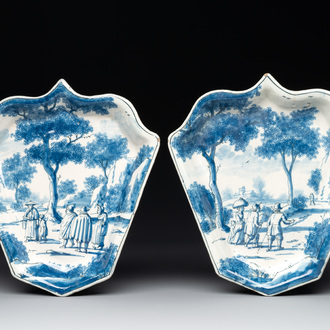 A pair of fine blue and white Dutch Delft leaf-shaped dishes with travellers in a landscape, early 18th C.