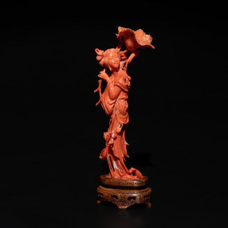 A Chinese red coral figure of a standing lady holding a flower, 19/20th C.