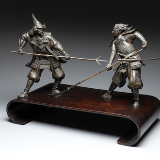 A fine pair of Japanese bronze warriors mounted on a wooden stand, Meiji/Taisho, 19/20th C.