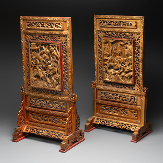 A pair of Chinese gilt-lacquered openworked wooden table screens with warriors on horseback, 19th C.