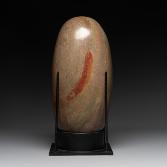 A large Shiva lingam stone on a metal stand