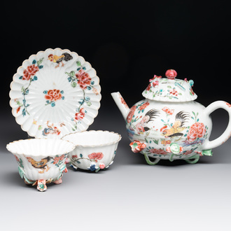 A Chinese famille rose 'rooster' teapot with applied floral design, two cups and a saucer, Yongzheng/Qianlong