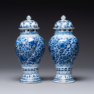 A pair of Chinese blue and white vases and covers with floral design, Kangxi