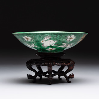 A Chinese verte biscuit 'animals among waves' bowl and a wooden stand, Jiajing mark, Kangxi