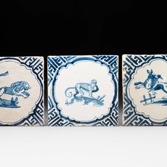 Three blue and white Dutch Delft tiles with a monkey, a lion and a fox with its prey, 17th C.