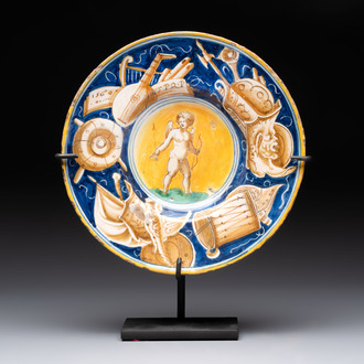 A polychrome Italian maiolica plate with Cupid holding an arrow, Casteldurante, dated 1560