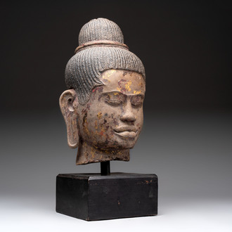 A Cambodian stone head of Shiva with braided hair and traces of gilt lacquer, Khmer Baphuon-style, 20th C.