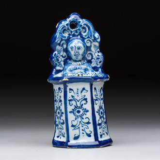 A blue and white Dutch Delft group of a child seated in a high chair, 18th C.