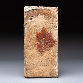 A Spanish cold-painted 'socarrat' or ceiling tile with stylised floral design, 15th C.
