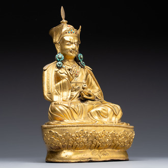 A Tibetan gilt-bronze figure of Padmasambhava holding a cup and a vajra, 17th C. or later