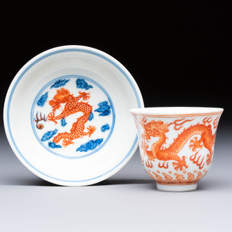 A Chinese iron-red decorated blue and white 'Dragon' saucer and a cup, Yongzheng and Tongzhi mark, 19/20th C.