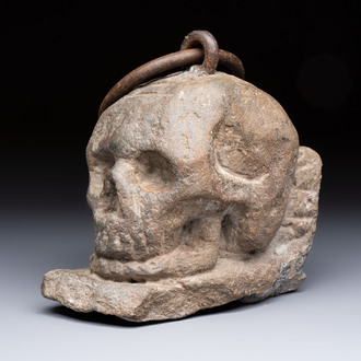 An Italian carved Serena stone 'Memento Mori' in the form of a skull with a wrought-iron suspension ring, probably Tuscany, 17th C.