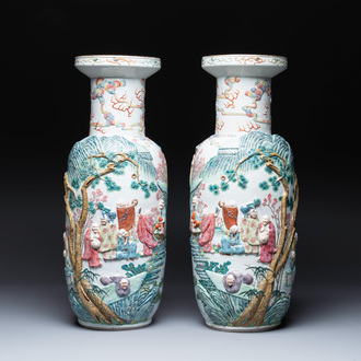 A pair of Chinese famille rose '18 Luohan' vases with relief design, 19th C.