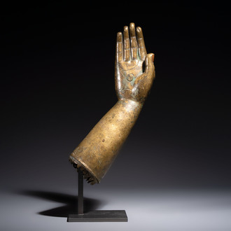 A rare and large Tibetan bronze forearm of a Buddhist figure with a chakra design, on a later metal stand, Qing