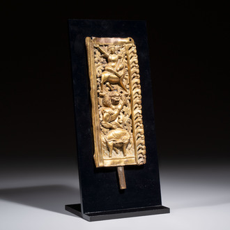A fine Tibetan gilt-copper repoussé plaque depicting a Dharmapala, a lion and an elephant, on a later mount, 18th C.