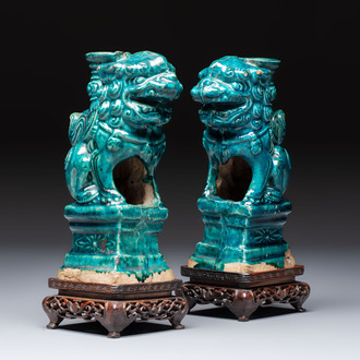 A pair of Chinese turquoise-glazed lion-shaped joss stick holders on wooden stands, Ming
