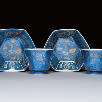 A pair of Chinese gilt-decorated powder-blue-ground 'Antiquities' cups and saucers, lingzhi mark, Kangxi