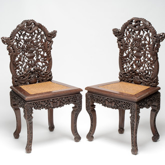 A pair of richly carved Chinese hongmu 'Dragon' chairs with cane seats, 19th C.