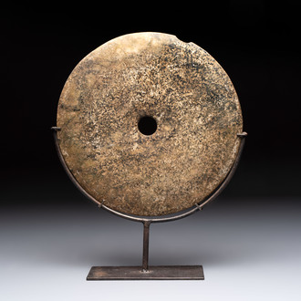 A Chinese archaic calcified jade 'bi' disc on an iron stand, possibly Zhou