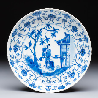 A Chinese blue and white 'Elegant Lady with Two Boys' plate with a 'Lotus Scroll' border, Kangxi