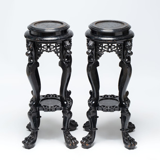 A pair of black-lacquered carved wood chinoiserie stands on lion feet, 19th C.