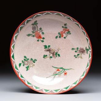 An unusual Chinese famille verte copper-red-ground shallow bowl with floral design, 19th C.