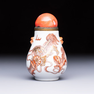 A Chinese gilt-decorated iron-red 'Buddhist Lions' snuff bottle with a red coral stopper, Buddhist Lion mark, Republic