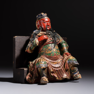 A Chinese gilt and polychrome lacquered papier-mâché and wooden Guandi on a wooden stand, 19th C.