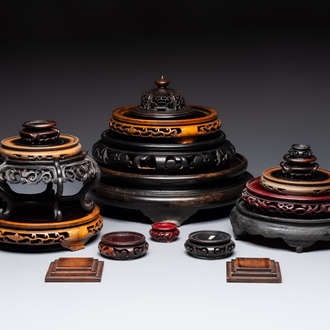 A Chinese reticulated wooden cover and 17 wooden stands, 19/20th C.
