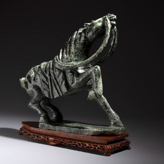 A large Chinese carved serpentine horse on a wooden stand, 20th C.