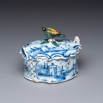 A blue and white Dutch Delft butter tub with a polychrome bird-shaped finial, 18th C.