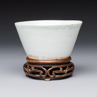 A Chinese white-glazed cup on a wooden stand, 17th C.