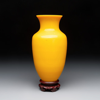 A Chinese yellow Peking glass vase on a wooden stand, 19th C.