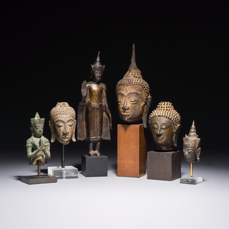 A bronze standing Buddha, a torso of Buddha and four heads of Buddha, Thailand, 17/18th C.