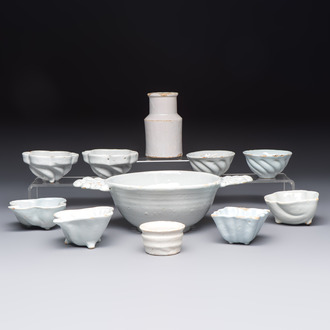 A collection of nine white-glazed Dutch Delft pudding moulds, a mustard pot and a two-handled strainer, 18th C.
