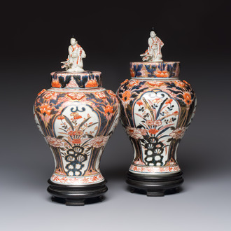 A pair of Japanese Imari baluster vases and covers on wooden stands, Edo, 18th C.