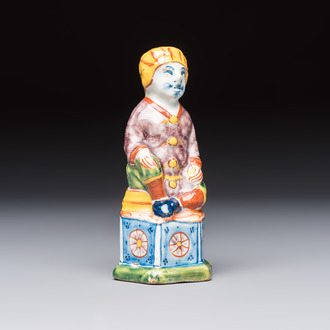 A polychrome Dutch Delft model of a seated oriental figure, 18th C.