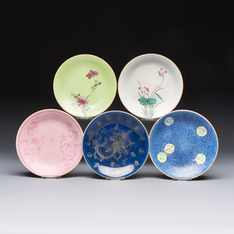 Four Chinese famille rose saucers and a gilt-decorated powder-blue-ground saucer, Qianlong and Jiaqing marks, 18/19th C.