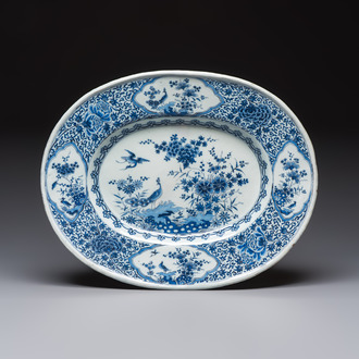 A very rare and massive blue and white Dutch Delft dish with peacocks in a garden, late 17th C.