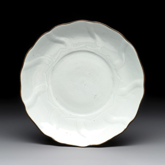 A Chinese moulded white-glazed plate with anhua floral design and a copper-mounted rim, Xuande mark, late Ming