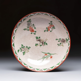 An unusual Chinese famille verte copper-red-ground shallow bowl with floral design, 19th C.