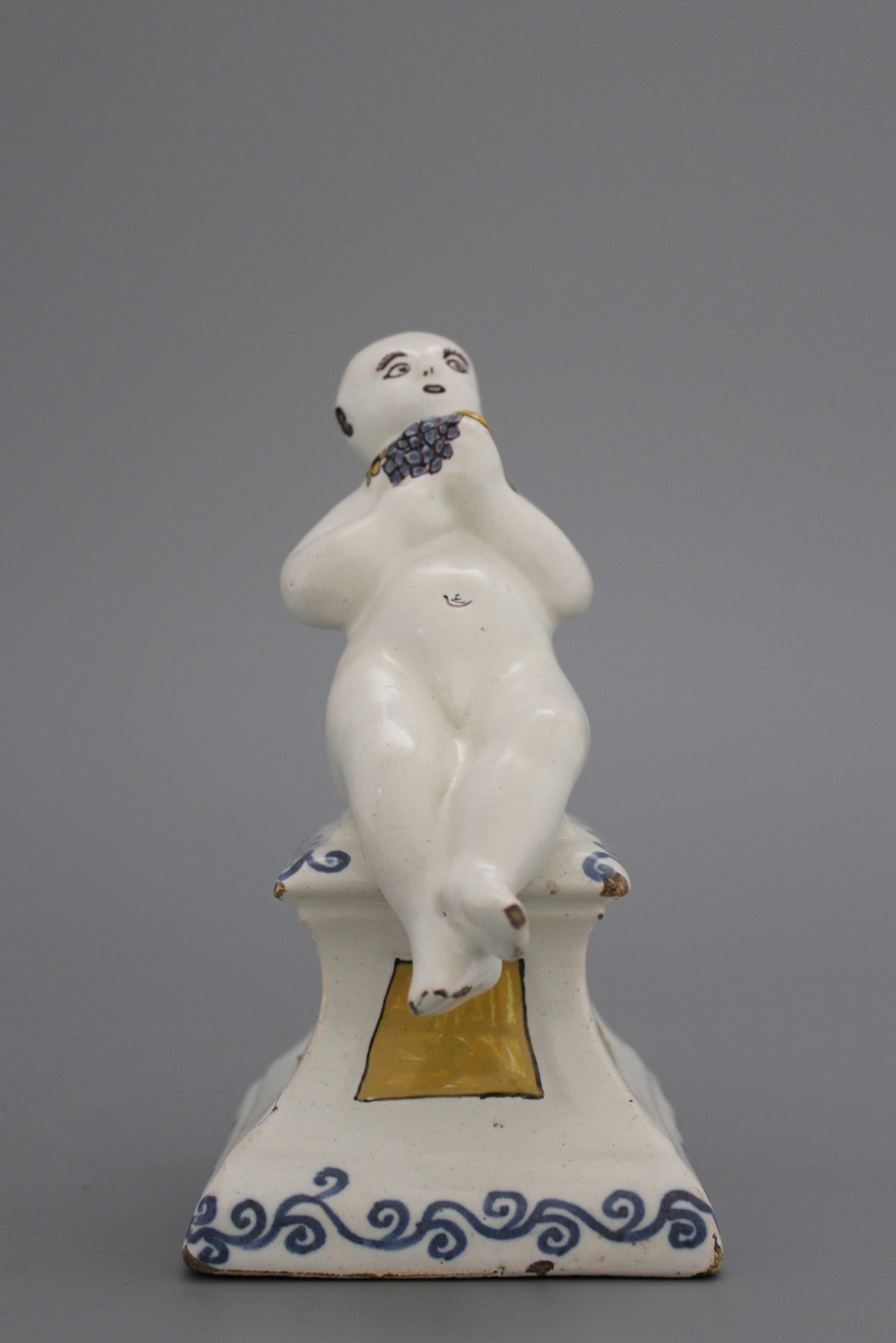 A French ceramic figure of a boy on a base, 18th C.