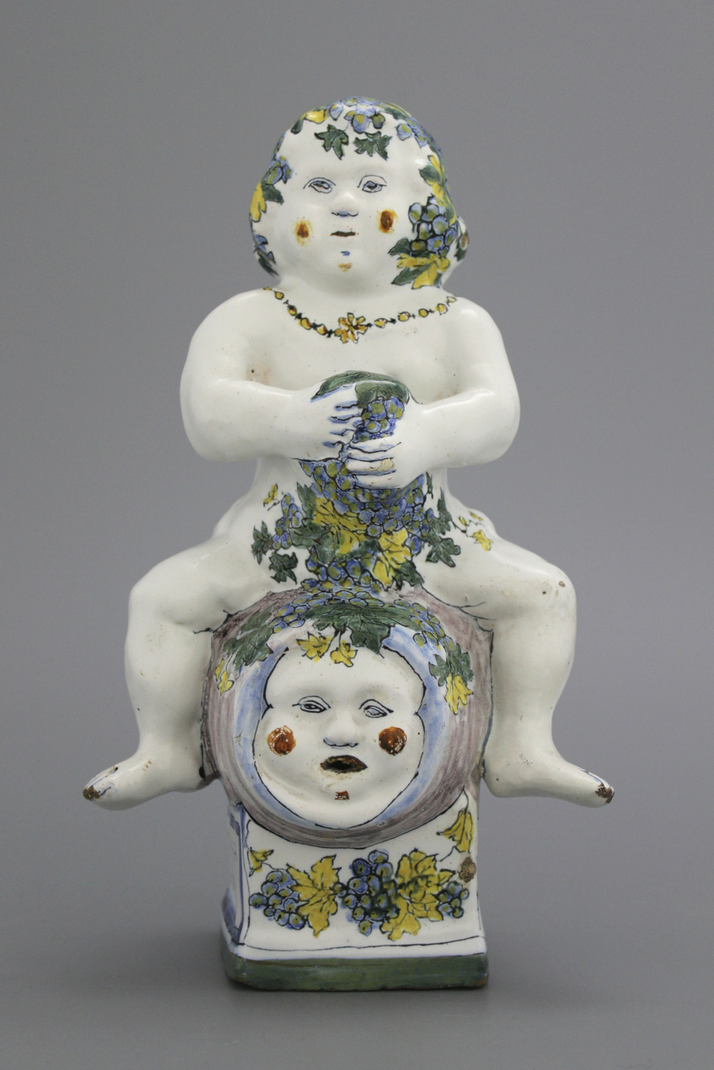 A Brussels faience table fountain, modelled as Bacchus seated on a barrel, 18th C.