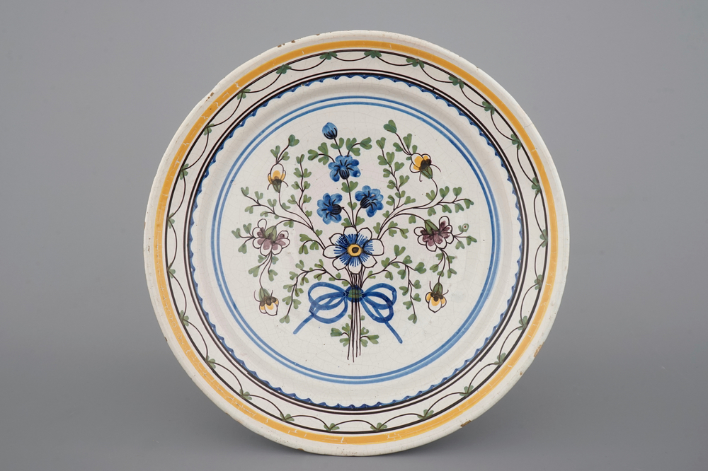 Un plat en fa&iuml;ence de Bruxelles d&eacute;cor&eacute; d'un bouquet de fleurs, 18&egrave;me si&egrave;cle