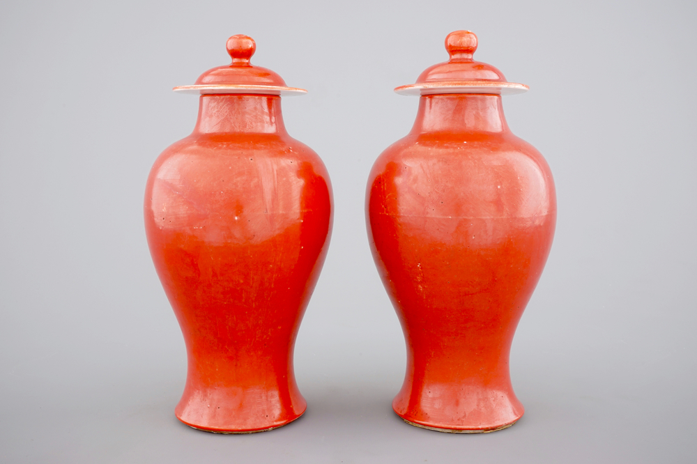 A pair of Chinese monochrome coral ground baluster vases with cover, 19th C.