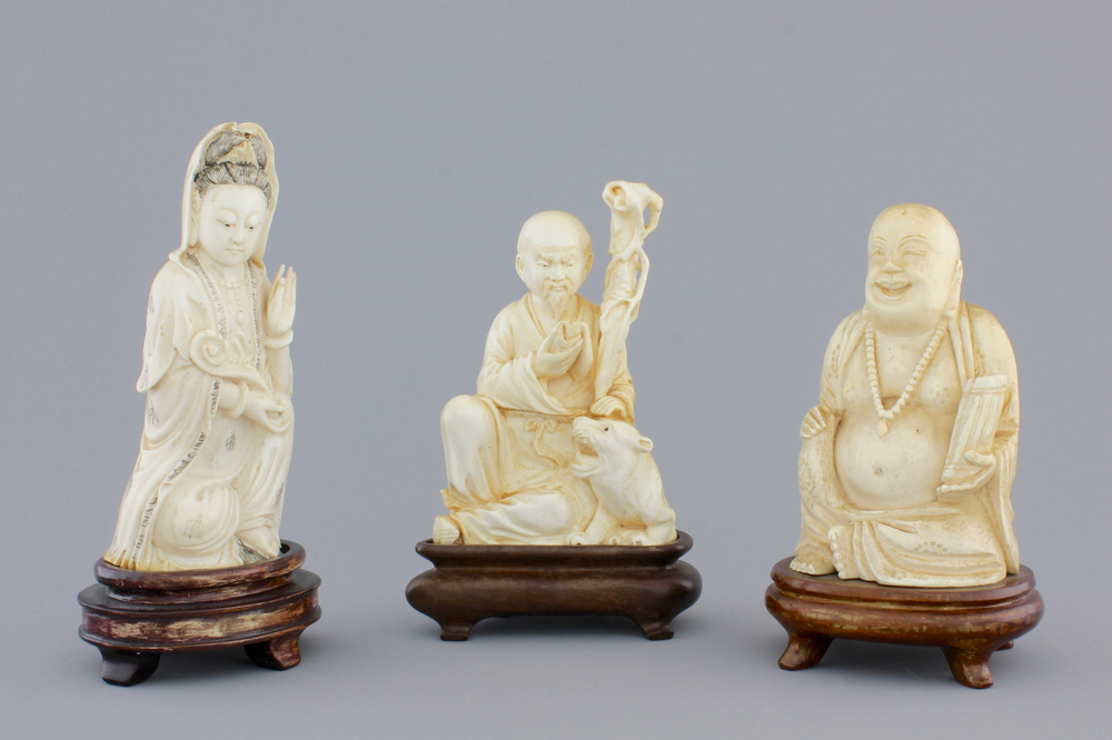 Three Chinese carved ivory figures on wooden stands, ca. 1900