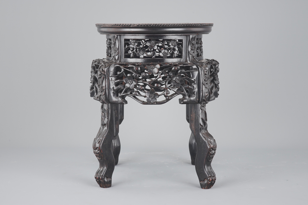 An elaborately carved Chinese hardwood vase stand with dreamstone insert, 19th C.