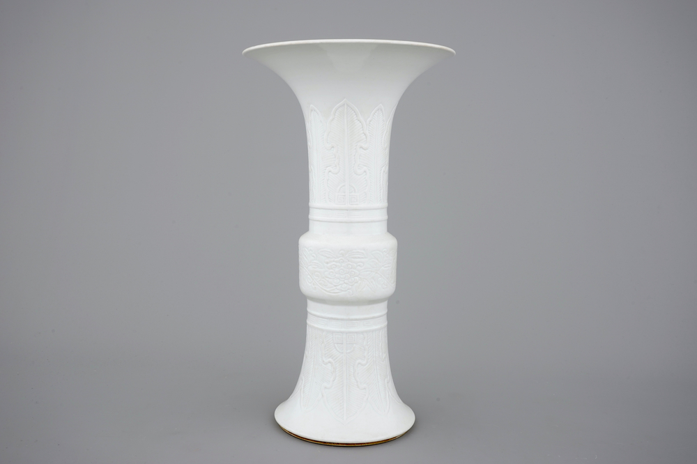 An elegant relief-decorated blanc de Chine porcelain beaker vase, 18/19th C.